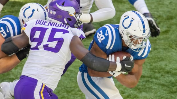 Sep 20, 2020; Indianapolis, Indiana, USA; Indianapolis Colts running back Jonathan Taylor (28) runs the ball while Minnesota Vikings defensive end Ifeadi Odenigbo (95) defends in the first quarter at Lucas Oil Stadium.